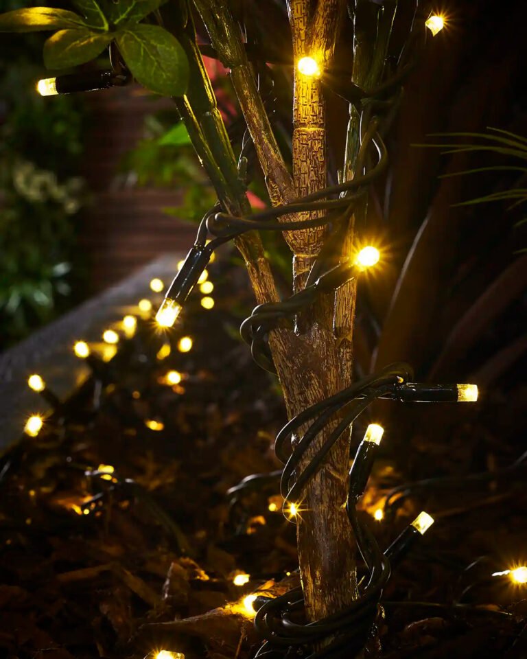 Gold connectable string lights wrapped around a plant stem